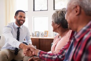 Retired Couple Shaking Hands With Financial Advisor